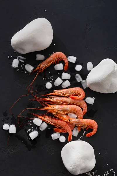 Siyah arka plan üzerine beyaz taşlarla karides