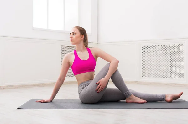 Frau trainiert Yoga in verdrehter Salbeipose. — Stockfoto