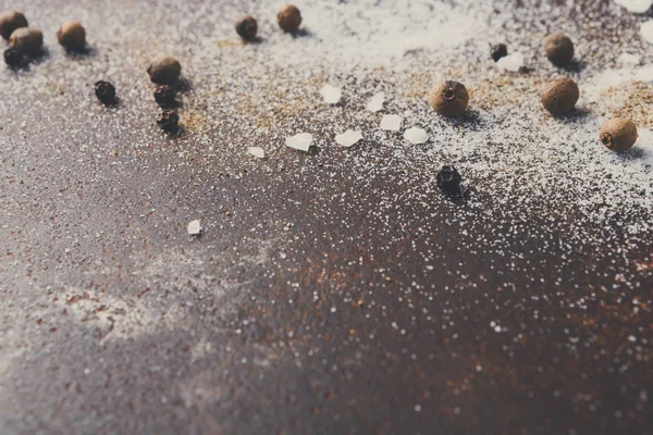 Salz und Pfeffer auf dunklem Hintergrund verstreut — Stockfoto