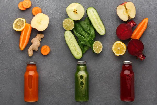 Smoothies gri arka plan üzerinde cam şişelerde malzemelerle Detoks.
