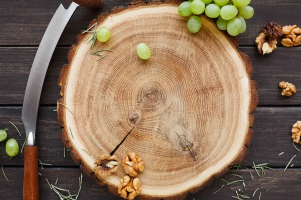 葡萄とナッツ、自然の木目テクスチャ背景を持つ木製ラウンド ディスク — ストック写真