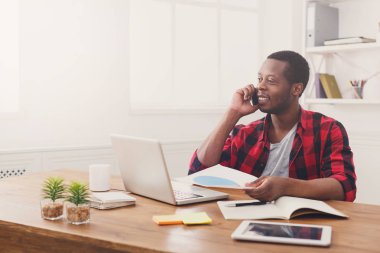 Genç siyah işadamı modern beyaz Office belgeleri okuyun