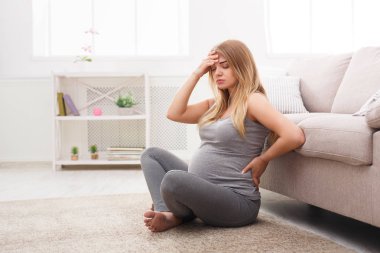 Genç hamile sarışın baş ağrısı ile