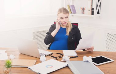 Hamile iş kadını işyerinde belgeleri okuma