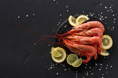 Siyah arka plan üzerine limon ve tuz ile karides