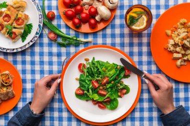 Damalı masa örtüsü arka planda, üstten görünüm sağlıklı yemek yeme kadın.