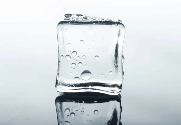 Cubo di ghiaccio trasparente con riflessione sul bianco — Foto Stock