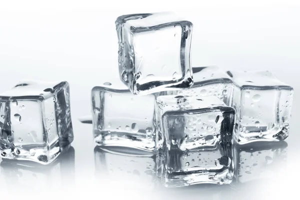 Прозрачные кубики льда с капельками воды на белом — стоковое фото