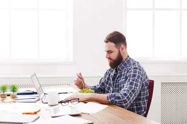 Man har friska affärslunch i moderna kontor inredning — Stockfoto