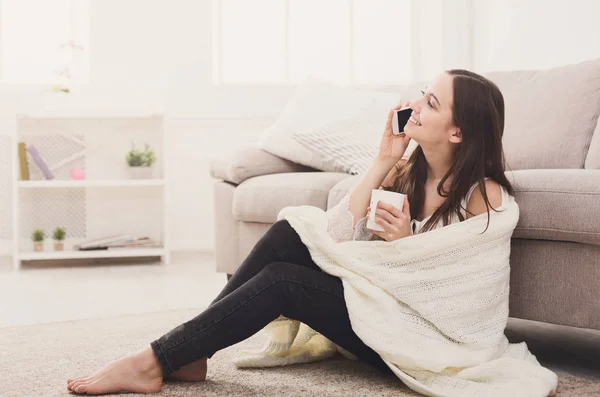 Cozy home. Girl in a blanket with mobile — Stock Photo, Image