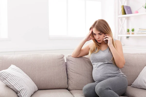 Inquiète femme enceinte parlant au téléphone — Photo