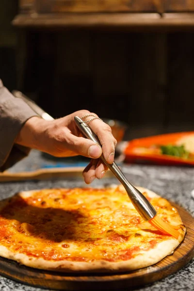 Koch schmiert Pizza mit geschmolzener Butter, Kopierraum — Stockfoto