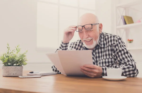 Fröhlicher älterer Mann sucht Fotos, kopiert Raum — Stockfoto