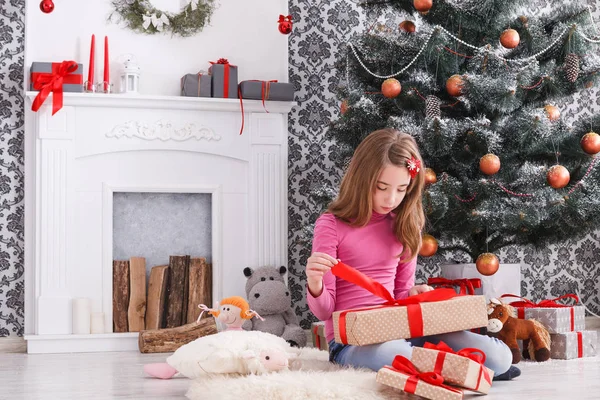 Menina bonita desembrulhando presentes de Natal — Fotografia de Stock
