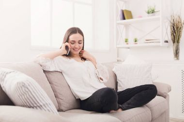 Genç bir kadın cep telefonuyla konuşuyor.