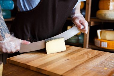 Bakkal dükkanında sert peynir kesme