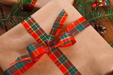 Noel hediye kutusu gri kağıdına sarılmış. Saten şerit yay, köknar dalı. Portre, kırpma.