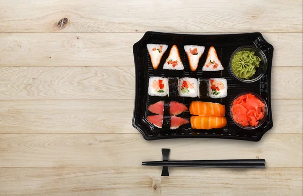 Japanese food delivery. Set of sushi and rolls top view on wood — Stock Photo, Image