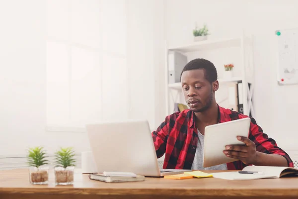 Ernstige jonge zwarte gelukkig zakenman in kantoor, werken met een laptop — Stockfoto