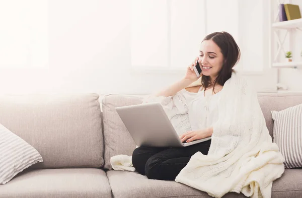 Ragazza in un plaid con un computer portatile e cellulare — Foto Stock