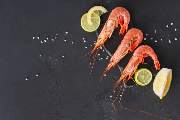 Siyah arka plan üzerine limon ve tuz ile karides
