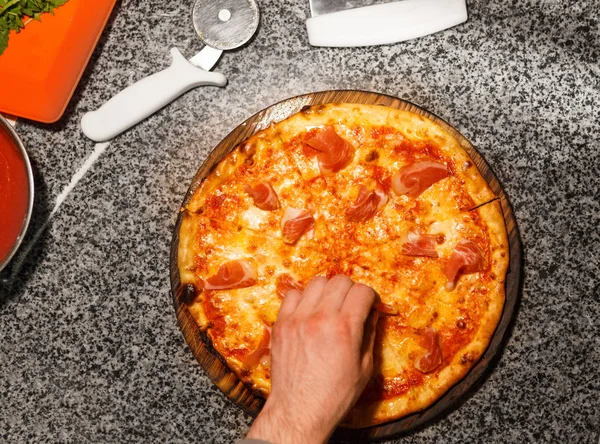 Prosciutto zur Pizza hinzufügen, Draufsicht — Stockfoto