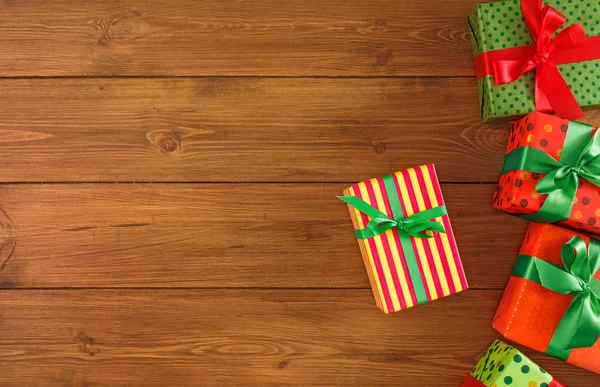 Fronteira de pacotes coloridos com vermelho, fitas verdes para o Natal, dia dos namorados ou aniversário. Vista superior, espaço de cópia — Fotografia de Stock