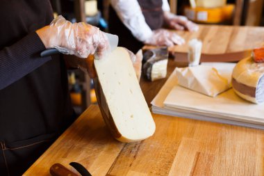 Bakkal dükkanında sert peynir kesme