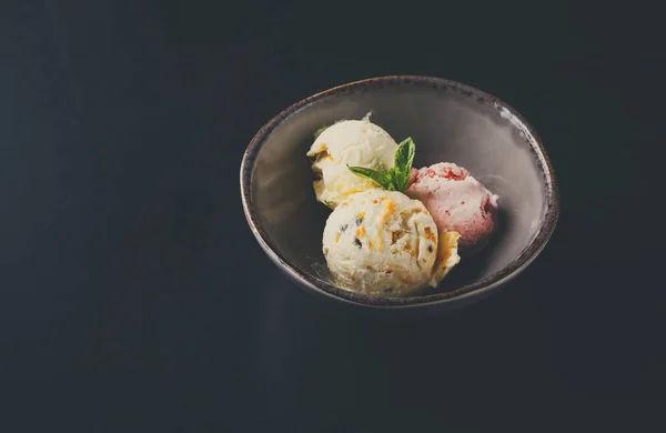 Scoop di gelato assortiti in ciotola su nero — Foto Stock