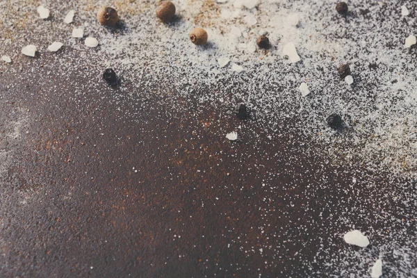 Sal y pimienta dispersas sobre fondo oscuro — Foto de Stock