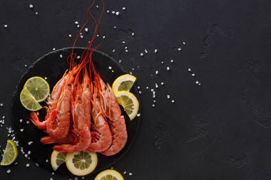 Siyah arka plan üzerine limon ve tuz ile karides