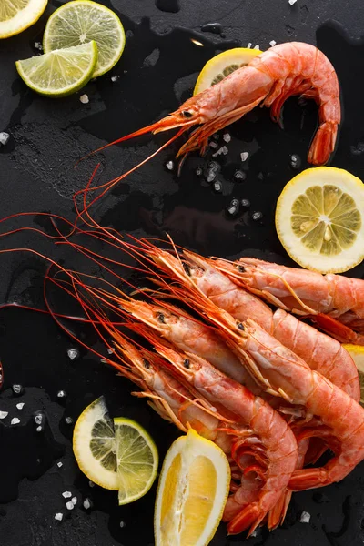 Siyah arka plan üzerine limon ve tuz ile karides