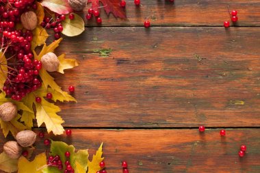 Sonbahar akçaağaç sarı yaprakları ve ahşap arka plan üzerinde çilek