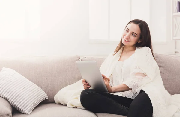 Gezellige huis. Meisje in een plaid met een tablet — Stockfoto