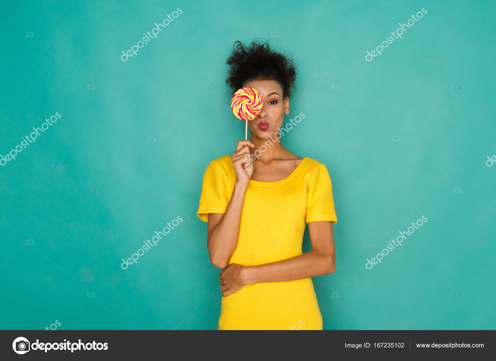 Glückliches MulattinMädchen mit Lutscher im Studiohintergrund