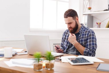 Cep telefonu tarafından dizüstü bilgisayar kullanarak Office genç işadamı