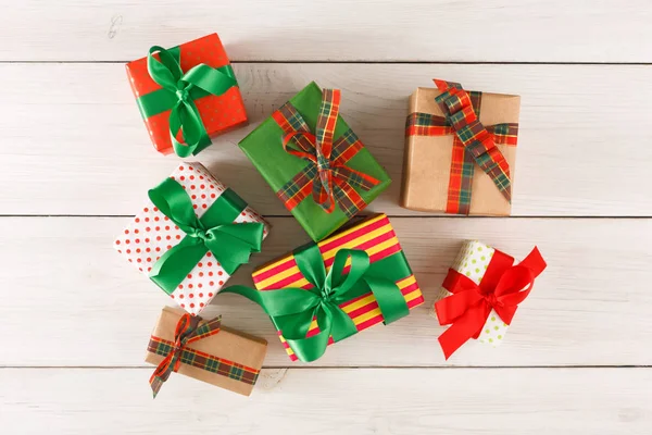 Regalos modernos hechos a mano en papel de color decorado con lazos de cinta de satén rojo, verde — Foto de Stock