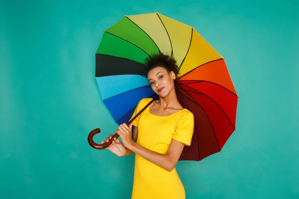 Happy girl with colorful umbrella at studio background — Stock Photo, Image