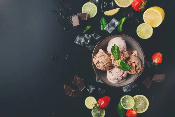 Porzione di misurini di gelato con frutta su nero — Foto Stock