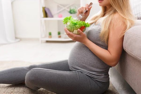 Молодая беременная женщина ест свежий салат крупным планом — стоковое фото