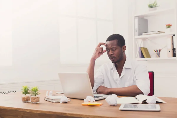 Tired african-american employee in office, work with laptop — Stock Photo, Image