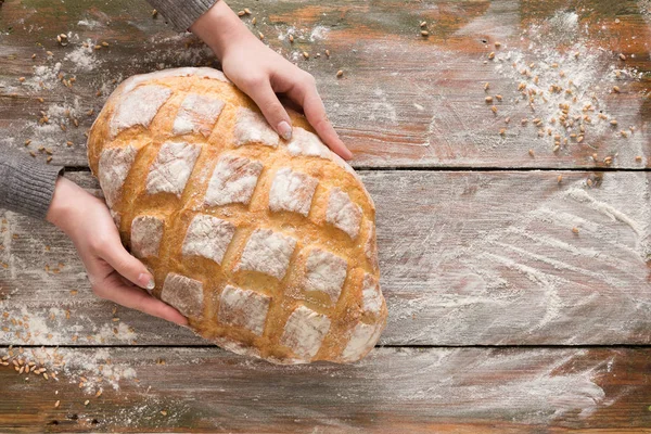 Fırın kavramı arka plan. Ekmek somun ellerini tutun