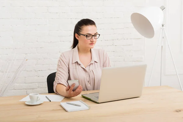 Geschäftsfrau mittleren Alters im Büro mit Telefon — Stockfoto