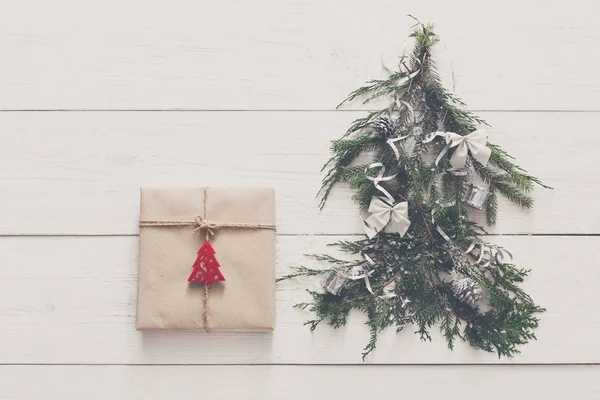 Χριστούγεννα με φόντο. Δώρο κουτί και fir tree στο λευκό ξύλο — Φωτογραφία Αρχείου