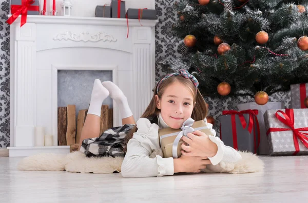 Hermosa niña y regalo de Navidad en el interior —  Fotos de Stock