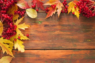 Sonbahar akçaağaç sarı yaprakları ve ahşap arka plan üzerinde çilek