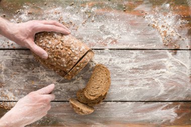 Fırın kavramı arka plan. Ekmek ekmek dilimleri kesme eller