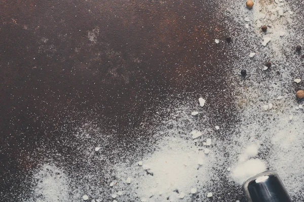 Sal e pimenta espalhados no fundo escuro — Fotografia de Stock