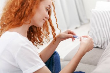 Endişeli kız onun gebelik testinin sonuçlarını okuma