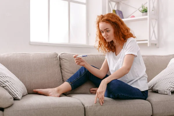 Endişeli kız onun gebelik testinin sonuçlarını okuma